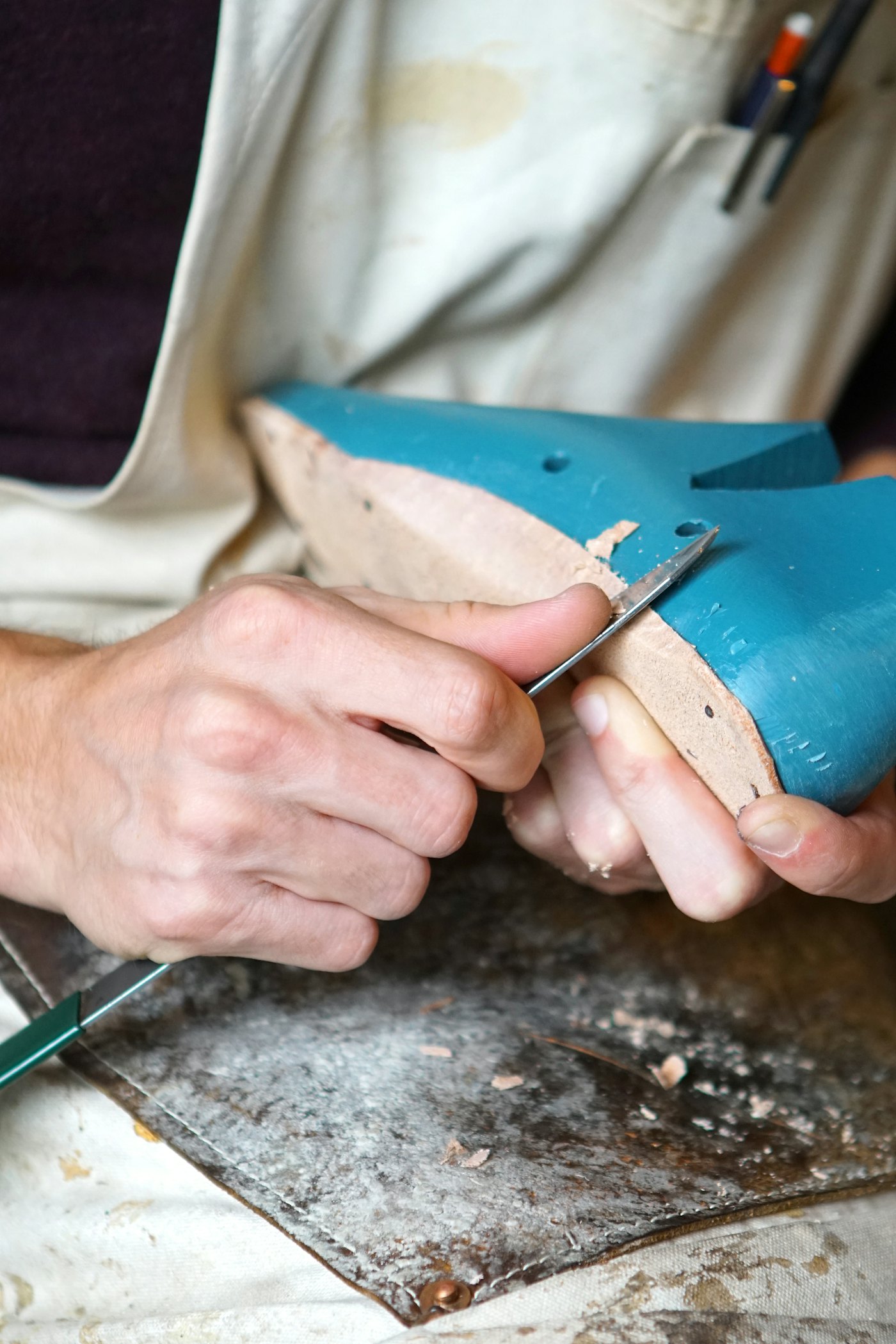 Handen van een schoenmaker aan het werk
